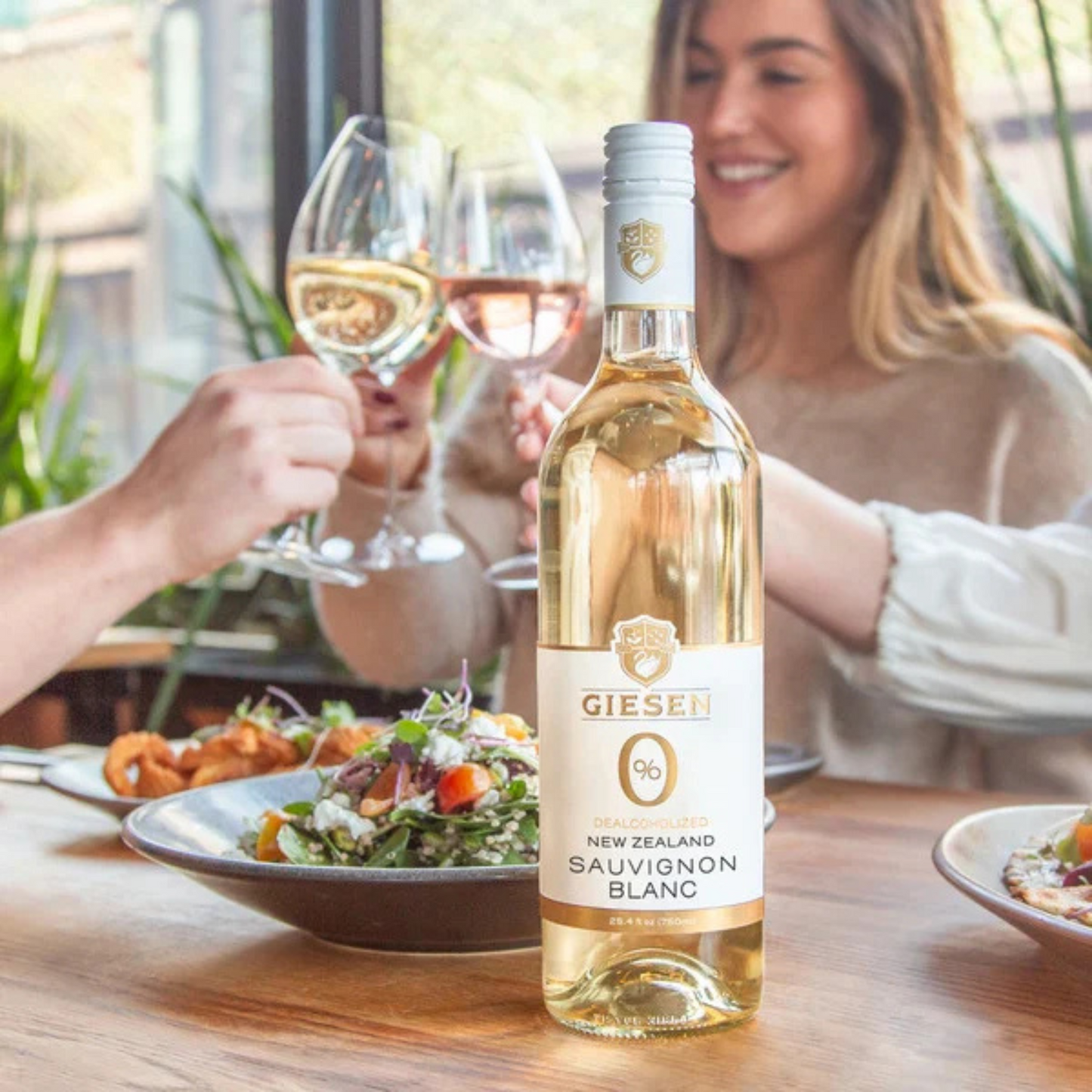 Bottle of Gieser Sauvignon Blanc with people enjoying a meal in the background