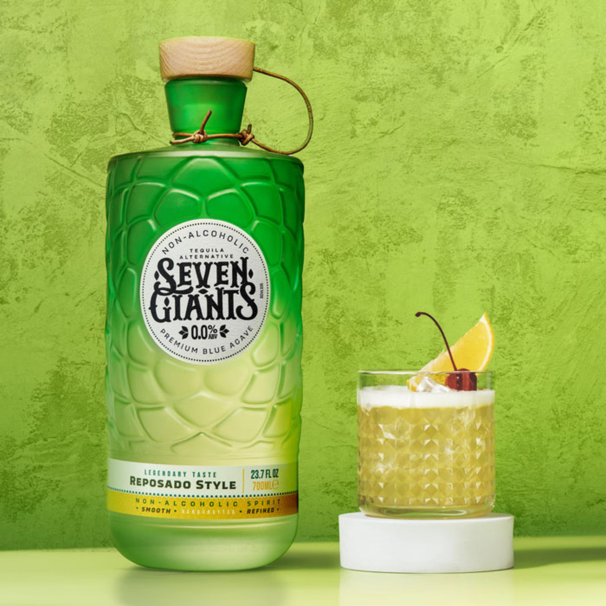 Green bottle of Seven Giants non-alcoholic beverage with a glass of cocktail on a green background