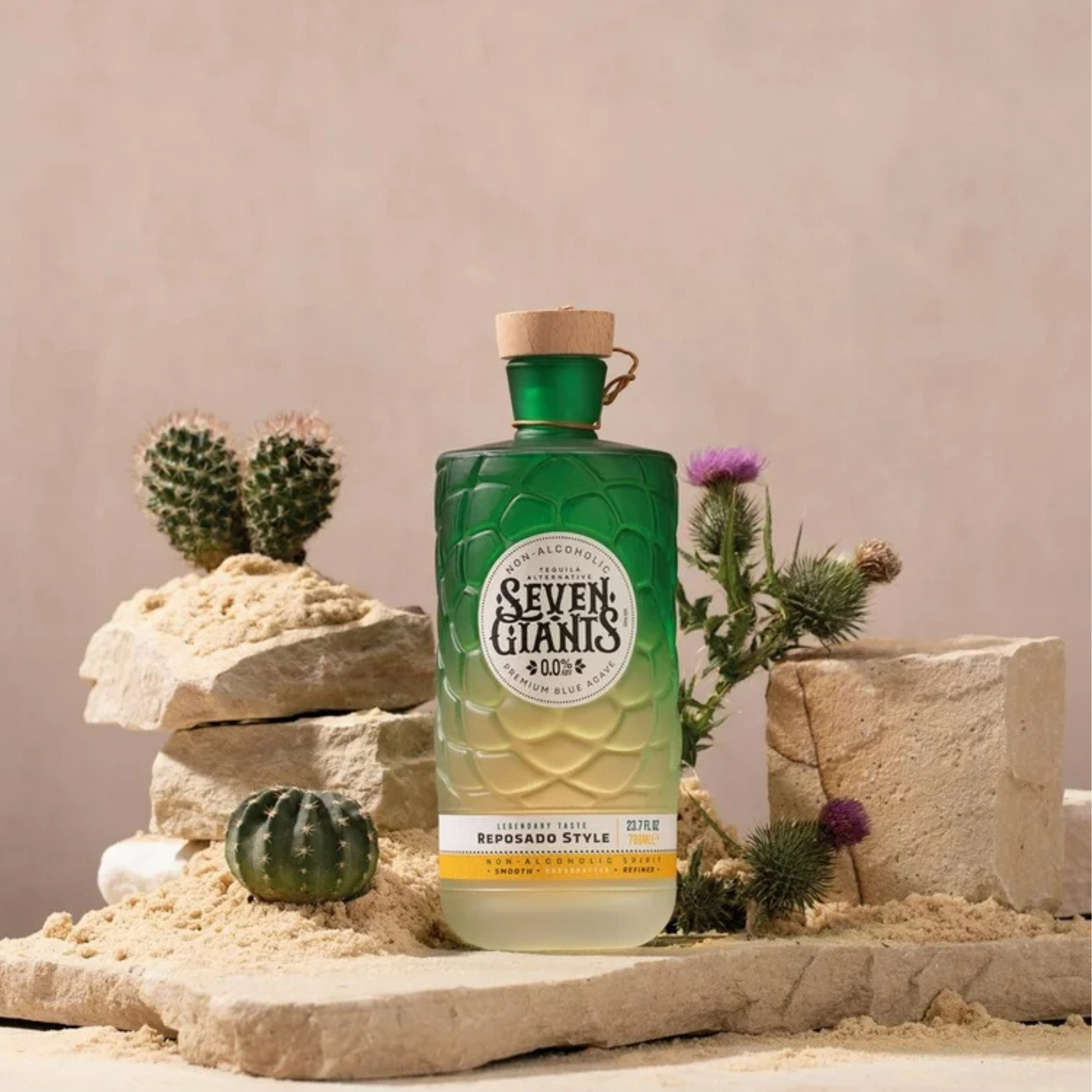 Green bottle labeled 'Seven Giants' with cacti and rocks in the background
