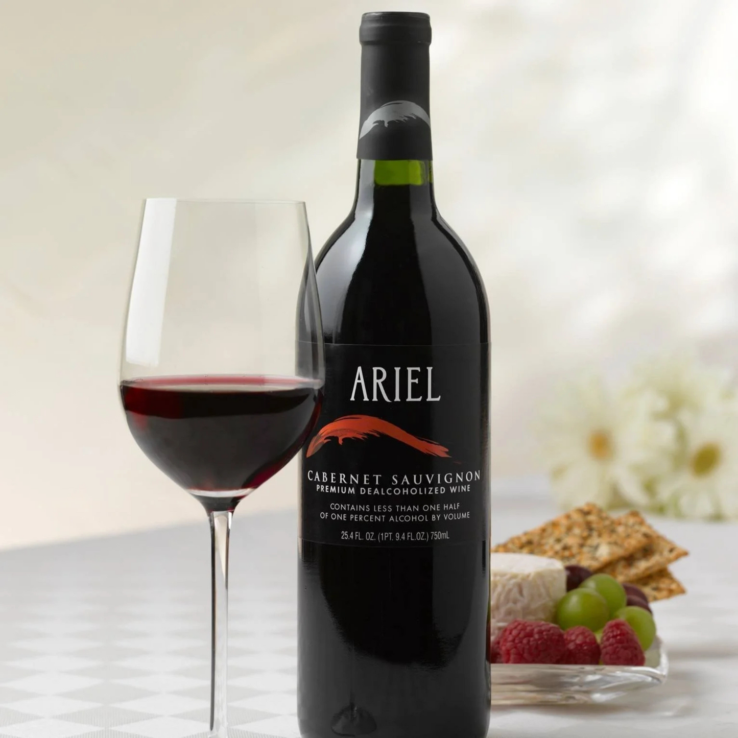 Bottle of Ariel Cabernet Sauvignon wine with a glass of wine and snacks on a table.