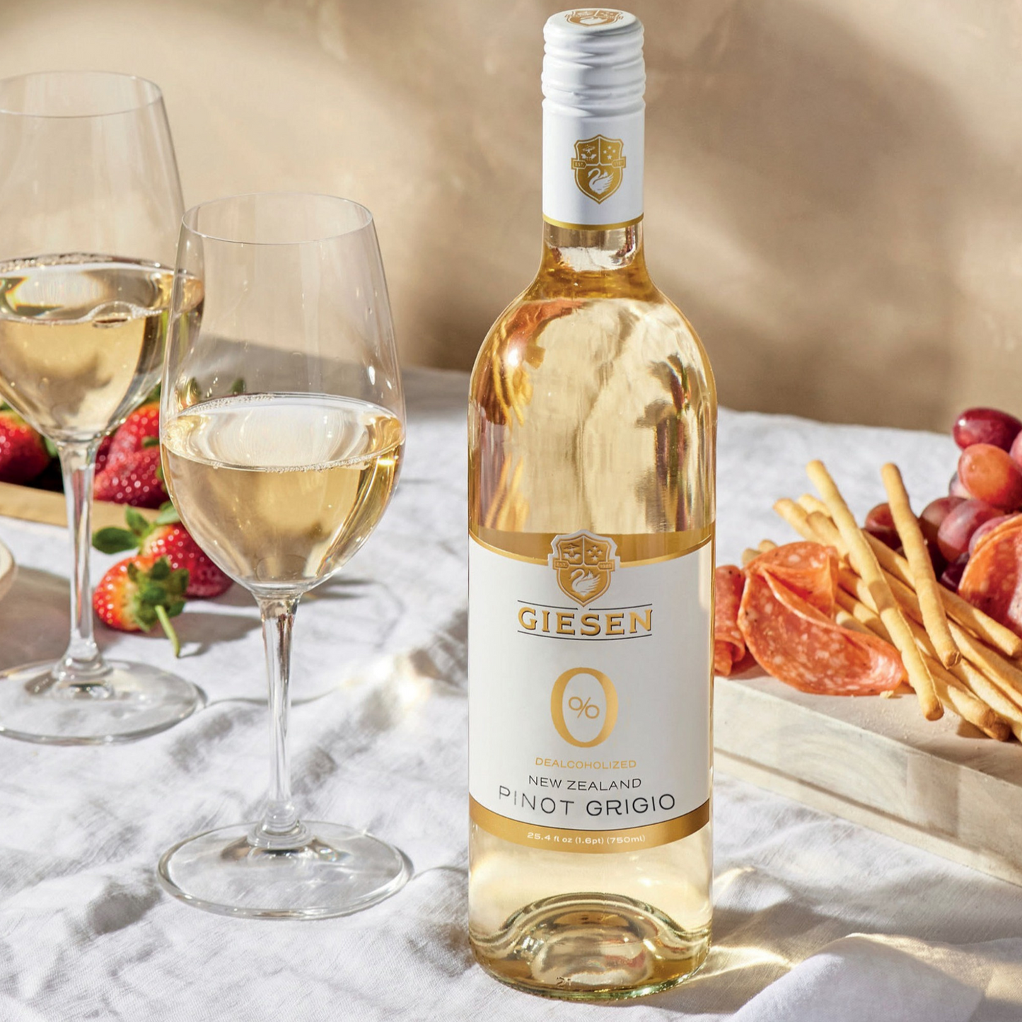 Bottle of Giesen Pinot Grigio with two glasses and snacks on a table