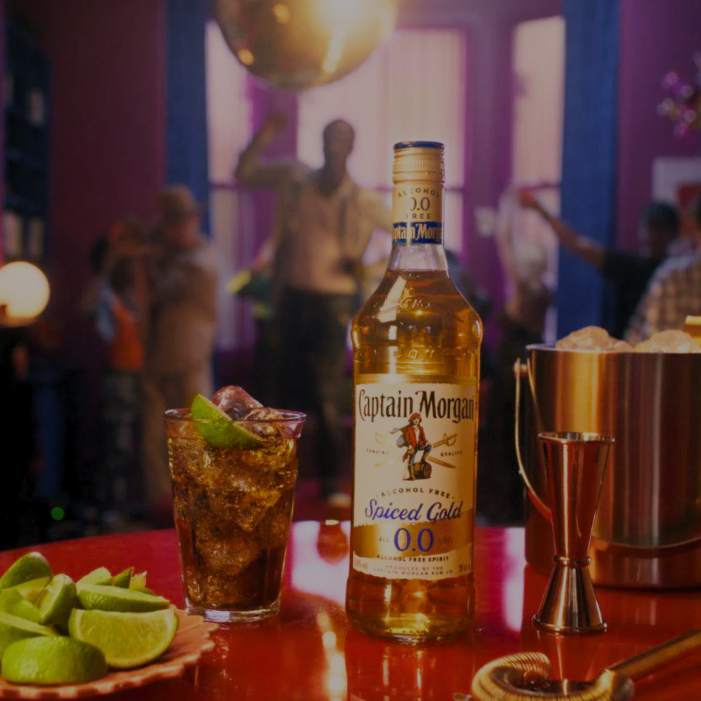 Captain Morgan Spiced Gold bottle with a cocktail on a bar counter in a lively bar setting