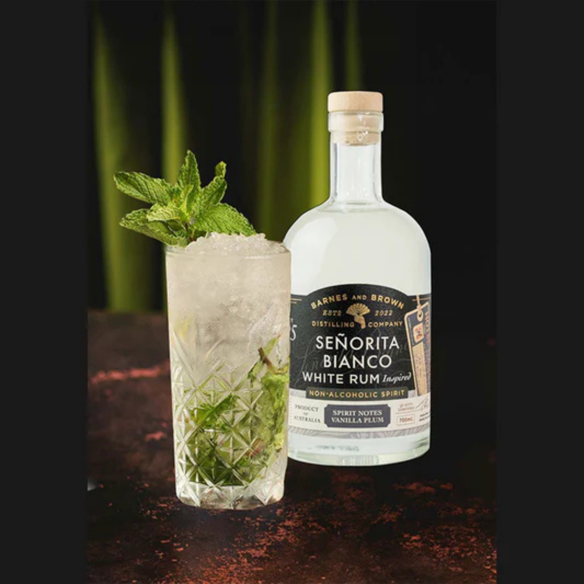 Bottle of Senorita Bianco White Rum and a cocktail with mint leaves on a dark background