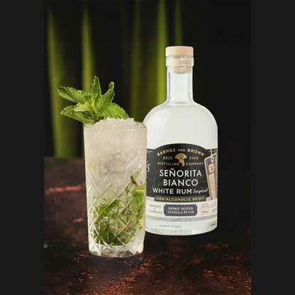 Bottle of Senorita Bianco White Rum and a cocktail with mint leaves on a dark background