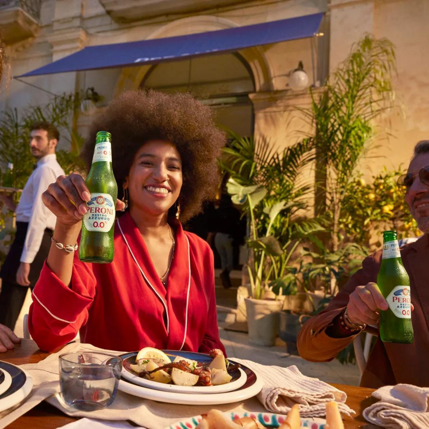 Woman holding a beer bottle outdoors with a casual setting